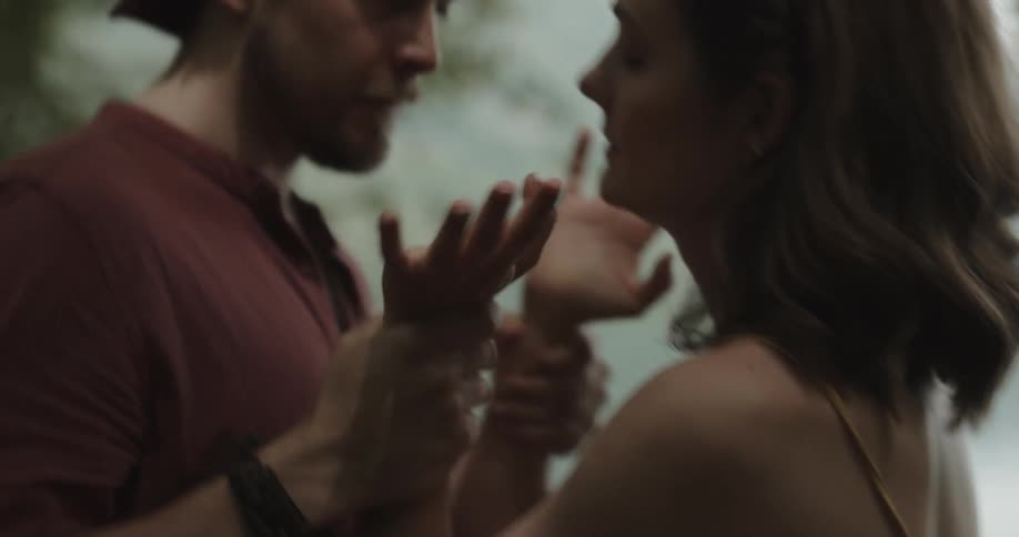 Angry woman arguing with her boyfriend and pushing him outdoors in the middle of the nature