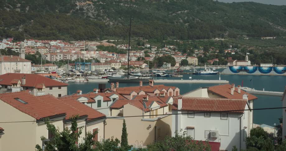 A marina in a town surrounding a bay during the day