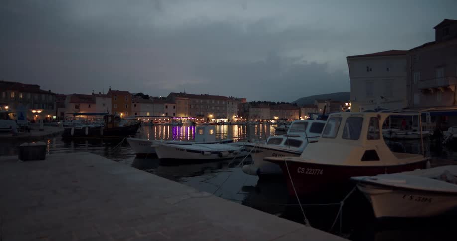 Boats docked in a marina in the evening