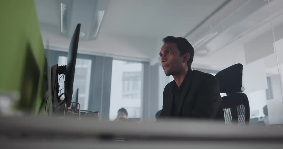 Man sitting at the desk in a shared office space working on his computer