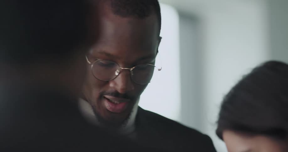 Three people standing in a office space having a meeting