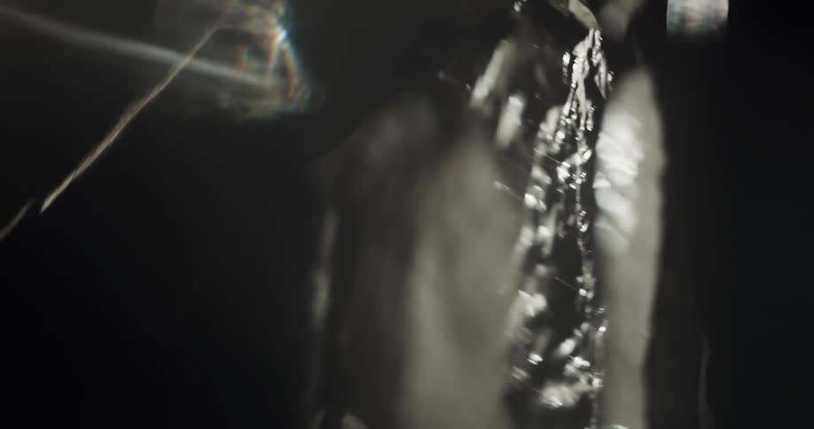 A person is hanging something in the dark