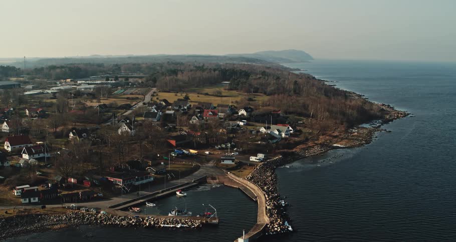 Aerial view of the bay in front of a a calm small coastal town close to the ocean at morning