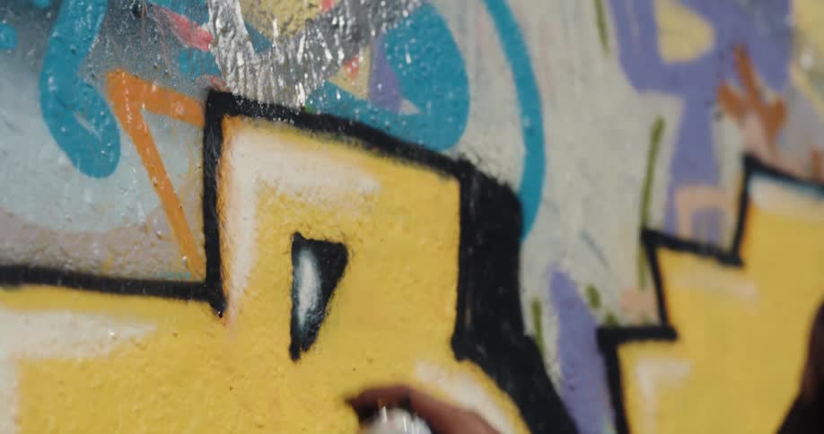 A person spray painting colorful art onto a wall