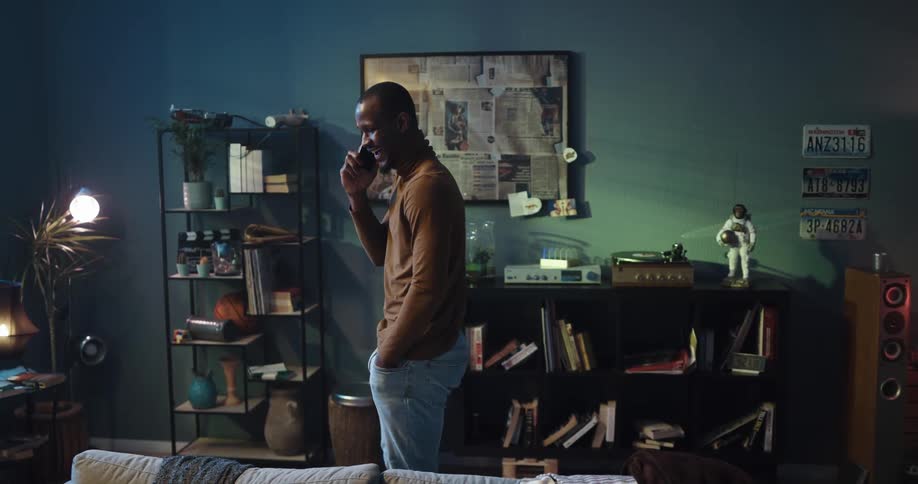Man walks past the retro record player as he talks on his cellphone