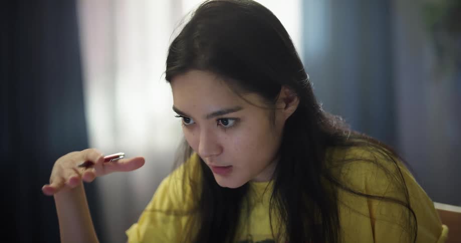 Young woman working from home attentively talking on a video call