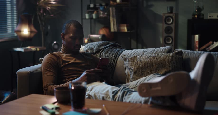 A man is resting on a couch in his house