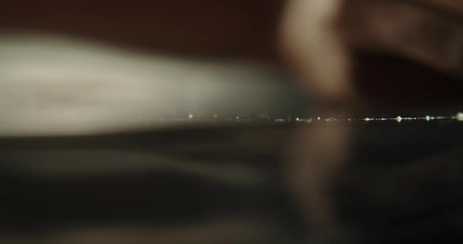 Close up of a man snorting a line of cocaine from a table