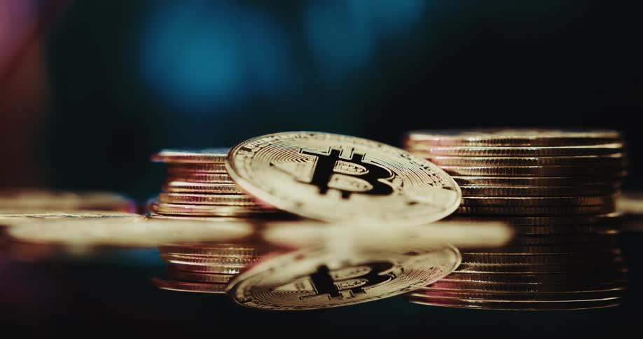 Stack of golden coins with the bitcoin logo printed on them