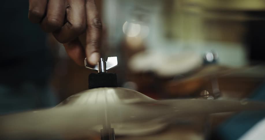 A person screws down his cymbal