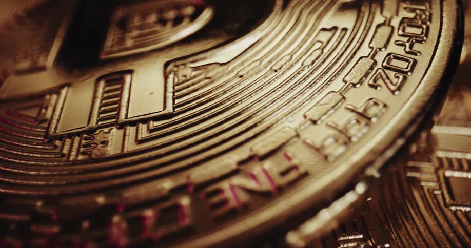 Close up view of gold bitcoins as the light shines on the ridges