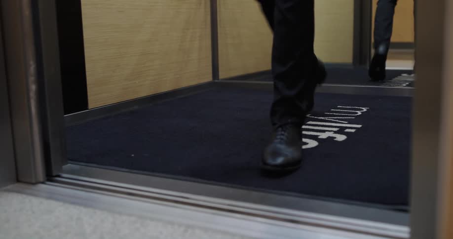 A person exiting an elevator indoors