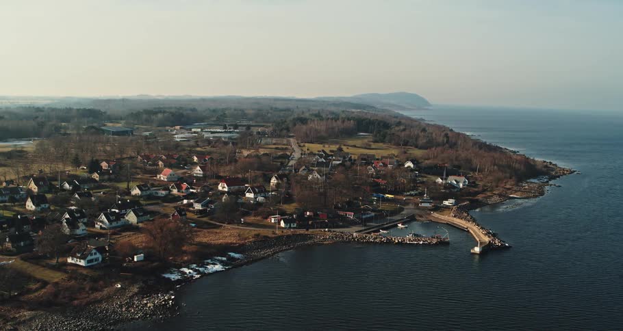 Aerial view of the bay in front of a a calm small coastal town close to the ocean at morning