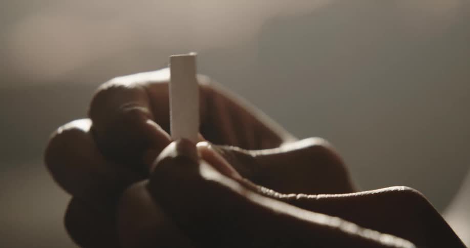 Person rolls small paper into tight roll