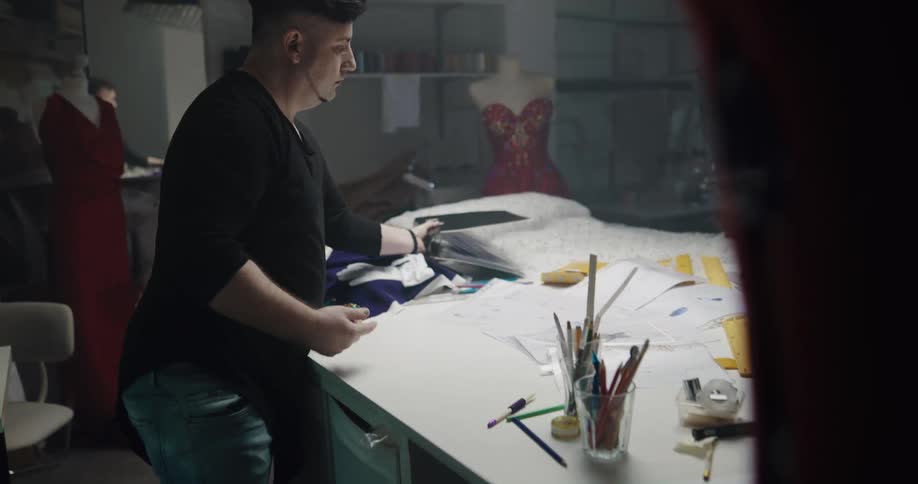 Man removes paper from a binder and puts the binder aside then gets more paper and writes on it
