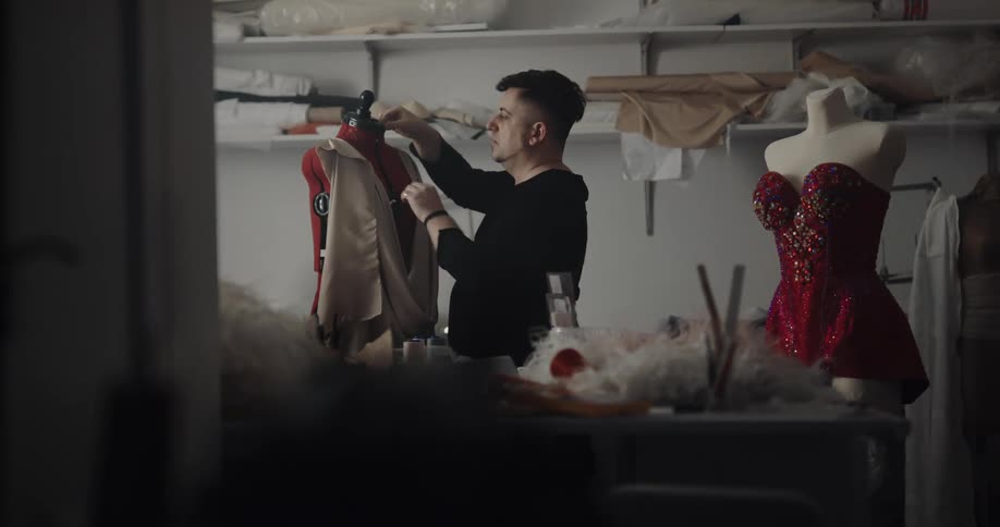 A fashion designer pins fabric to a mannequin
