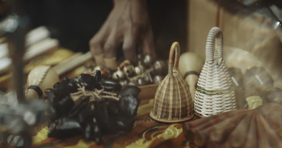 Hand lays something on the cloth then picks up a cluster of small bells