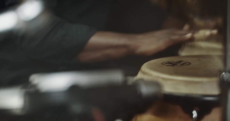 Musician plays music on hand drums inside a studio
