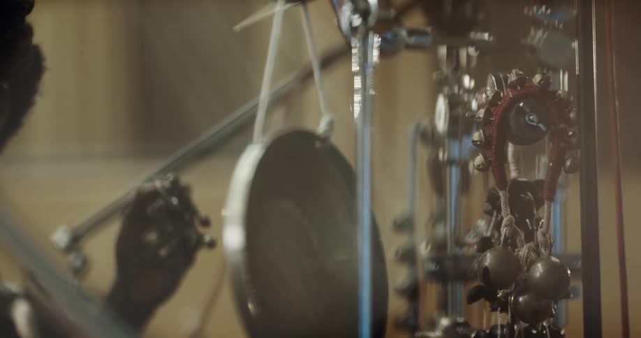 Musician shakes metallic bells inside a studio