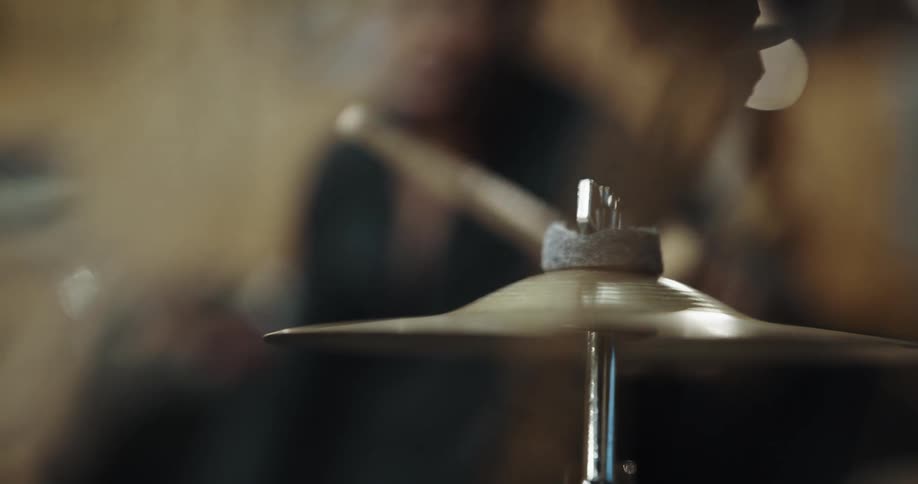 Musician taps a cymbal with a drumstick