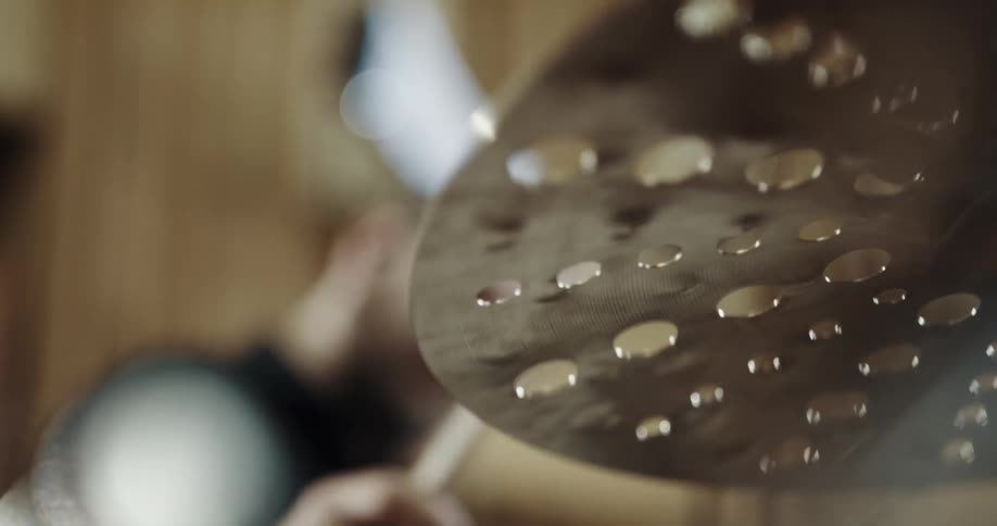 Male drummer with beard and black shirt plays drums