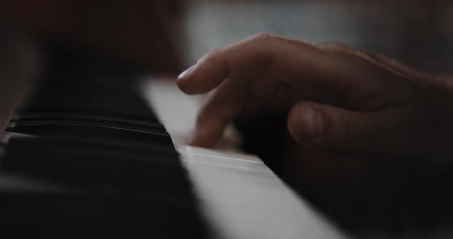 A pianist plays the keys rapidly with one hand