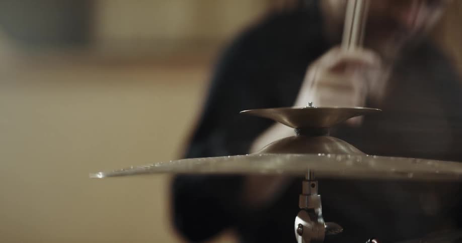 Male drummer with black shirt plays drums