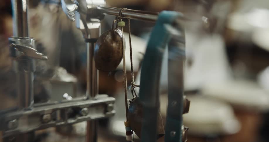 Musician playing percussion instruments rubs bells with a stick inside a studio