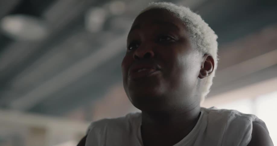 A black woman is shaking her head as she speaks to someone