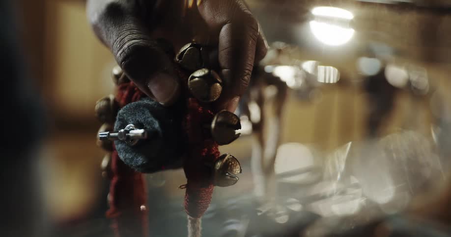 Person places jewelry containing metal bells over padded metal arm