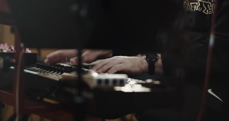 Musician playing a keyboard instrument inside a studio
