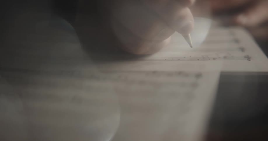 Someone is writing musical notes on a paper