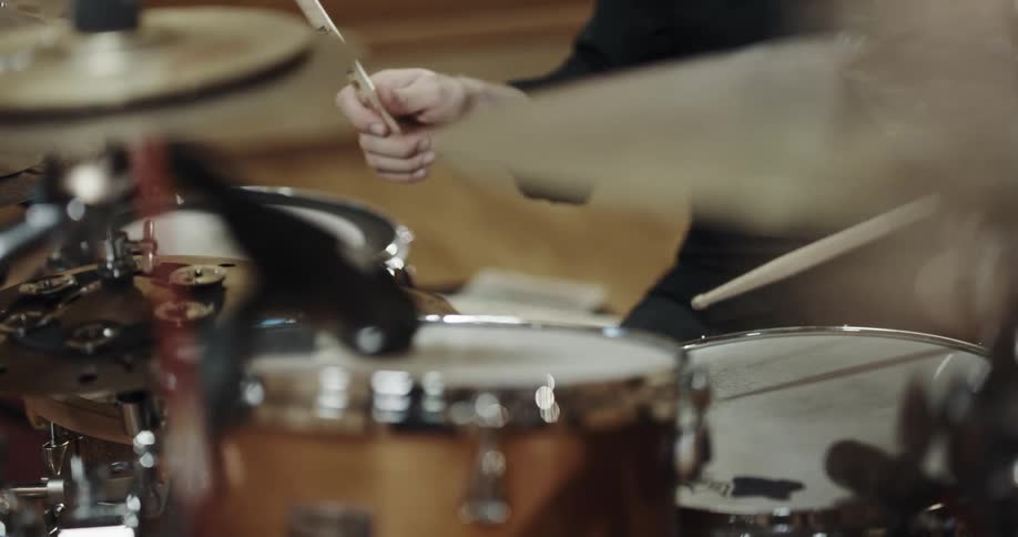 A percussionist plays drums in room with a wooden floor