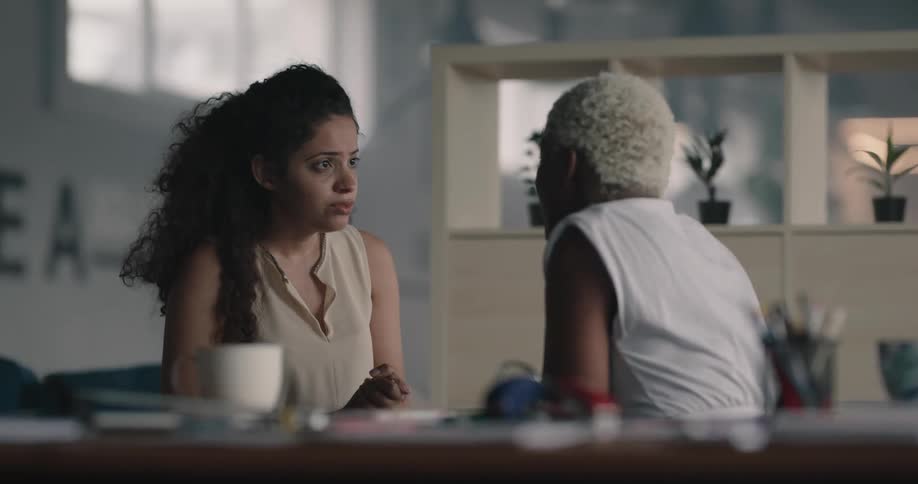 Younger woman shows compassion and encouragement towards an older woman as they sit and talk