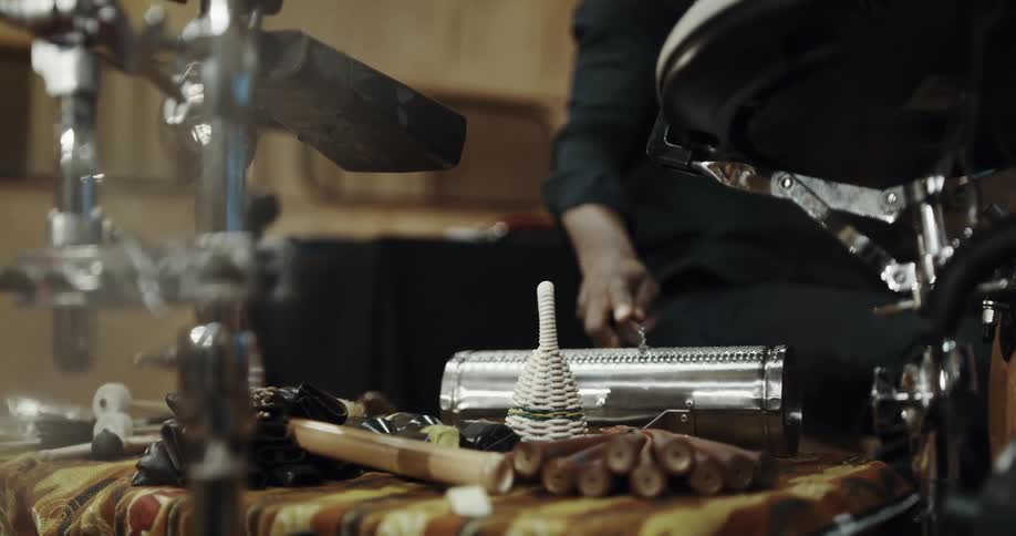 Man sitting in front of percussion instruments on a studio plays the jawbone