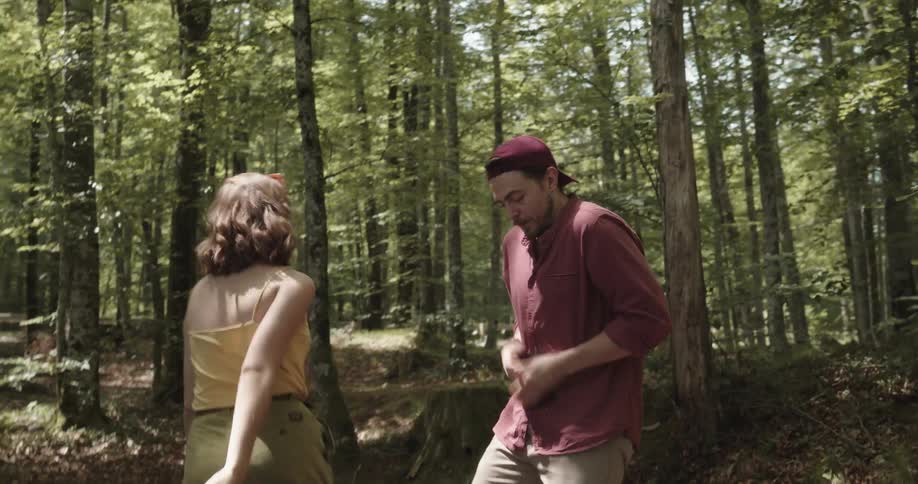 Young couple arguing over a the content of a phone while walking through a forest