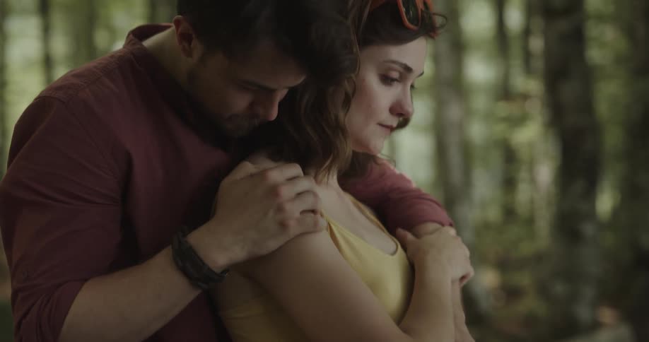 Close up of a man consoling his partner with a hug and kisses on her shoulder