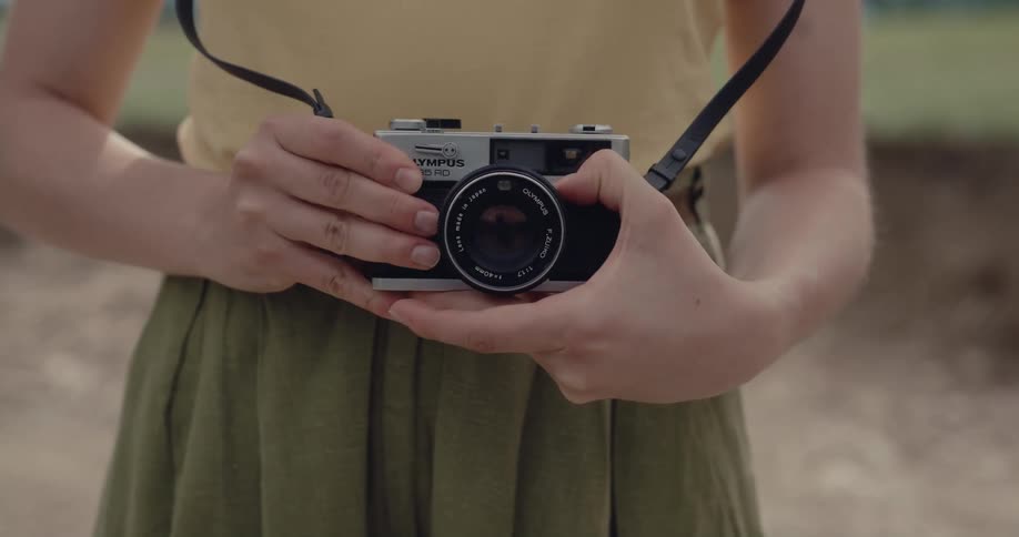 A woman taking a picture with a camera strapped around her neck