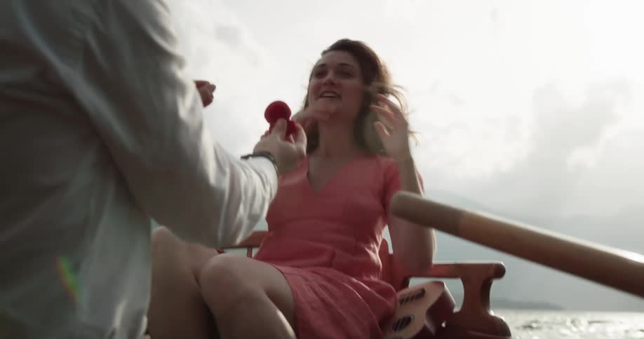 Man proposes to his partner inside a rowboat on the middle of a lake in the mountains
