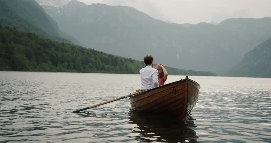 Man proposing to his girlfriend on a small wooden canoe in the middle of the lake