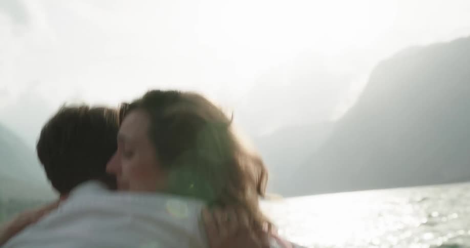 A woman fans her face with her hands to keep from crying when she says yes to her rowboat proposal