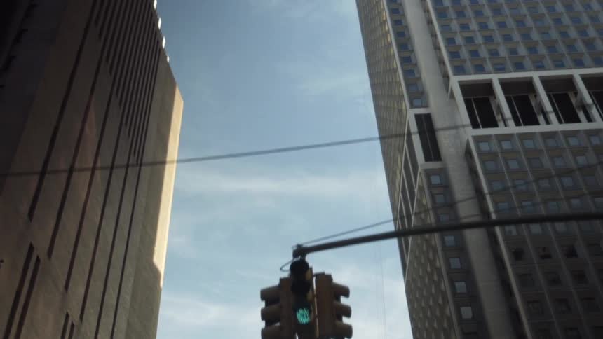 Moving down a street with traffic lights and tall buildings