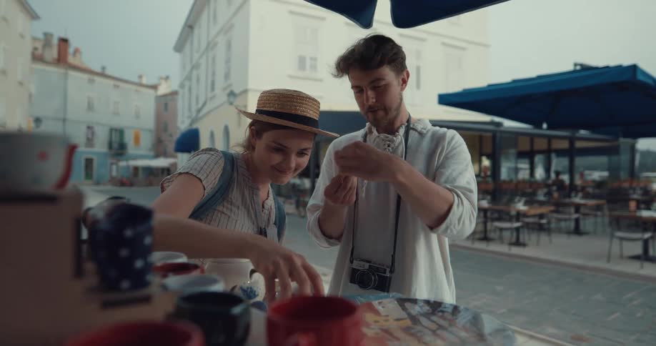 Young happy couple on vacation shopping from a street vendor in a small town