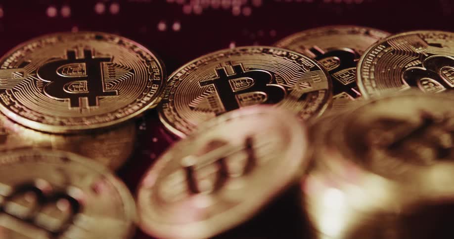 Gold plated bitcoin coins with logo shimmering in the light