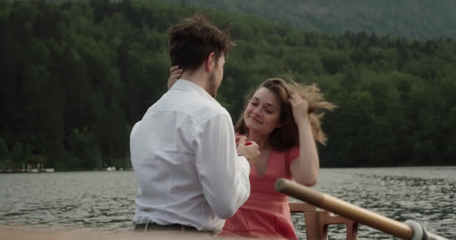 Woman and man are kissing on a boat during the daytime