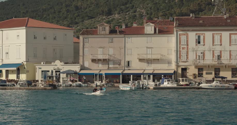 Coastal town with buildings overlooking sea and boats lying at anchor in the harbour