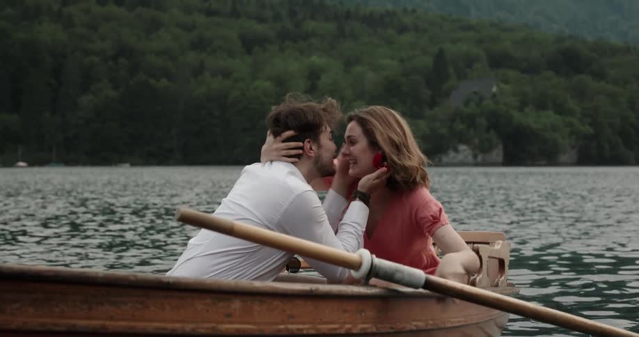 A man kisses his girlfriend and proposes to her in a canoe in the lake