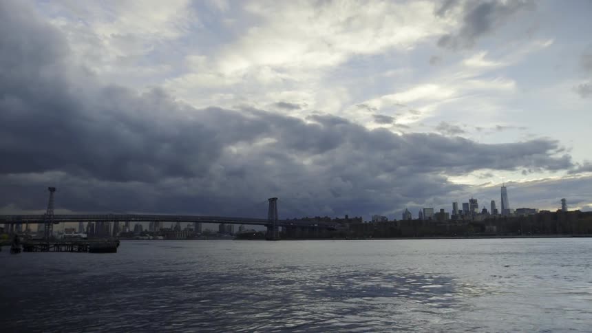 A city sits across the water on a cloudy day