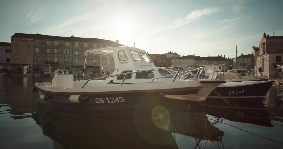 Boats docked on a pier in a waterfront small town at morning