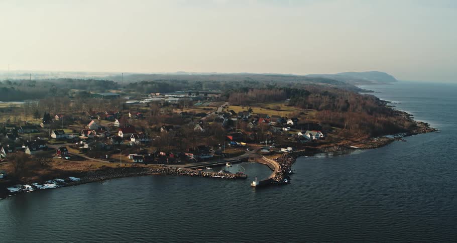 A waterfront village with stone jetty and docks in a protected harbour